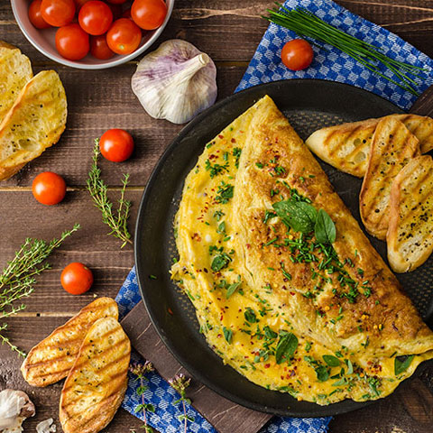 Omelet image from above with bread and tomatoes.