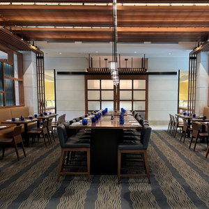 Large dining room at Plateia with tables, chairs, and place settings.